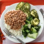 Refeição com arroz, feijão e verduras em fotografia de arquivo