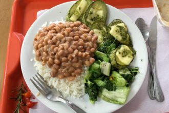 Refeição com arroz, feijão e verduras em fotografia de arquivo